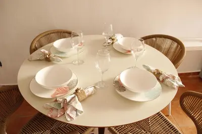 a white table with plates and wine glasses on it at Albatros by R&R 2 in Villas del Mar