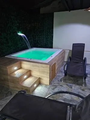 a hot tub with a fountain in a room with a chair at vista a toda la ciudad y montaña in San Felipe de Puerto Plata