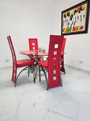 a dining room with red chairs and a table at vista a toda la ciudad y montaña in San Felipe de Puerto Plata