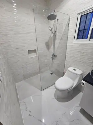 a white bathroom with a shower and a toilet at vista a toda la ciudad y montaña in San Felipe de Puerto Plata