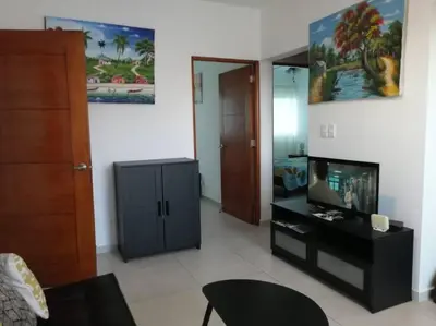 a living room with a tv and a cabinet at Rincón de Tranquilidad in Bayahibe