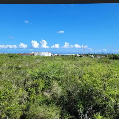 a field of green grass with a building in the background at Vibe Gorgeous one bedroom apartment view beach in La Laguna
