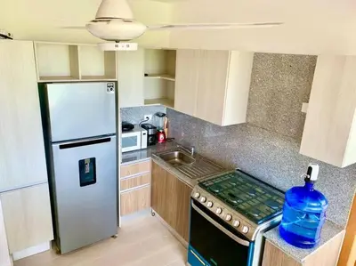 a small kitchen with a refrigerator and a sink at Gorgeous 2 bedroom apartment in Vibe Residence in Bayahibe