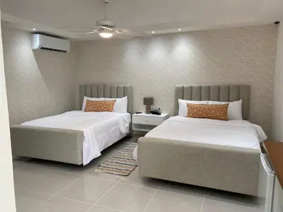 a bedroom with two beds and a couch at Sun on the bay beach hotel in Palmar de Ocoa