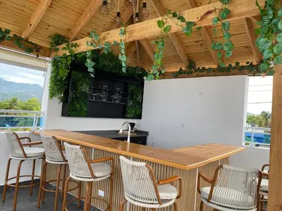 a kitchen with a bar with chairs around it at Sun on the bay beach hotel in Palmar de Ocoa