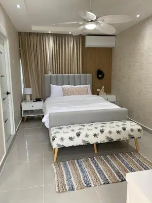 a bedroom with a large bed and a ceiling fan at Sun on the bay beach hotel in Palmar de Ocoa