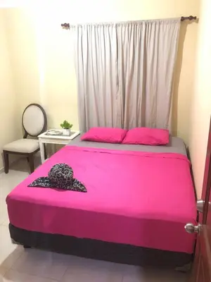 a bedroom with a pink bed with a window at Apartamento de Relajacion in Los Paredones