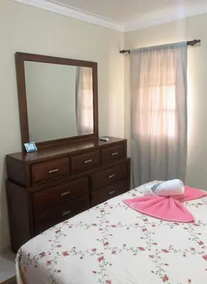 a bedroom with a dresser and a bed with a mirror at Apartamento de Relajacion in Los Paredones