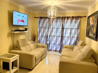 a living room with two couches and a tv at Confortable Apto de relajación in Los Paredones