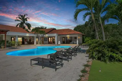 a swimming pool with chairs and a house at Casa de Campo villa – Luxurious villa up to 12 people with pool jacuzzi golf in La Romana