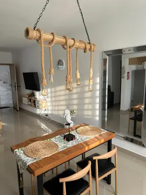 a dining table with two chairs and a chandelier at Samana Complexes Los Robles VII in Los Paredones