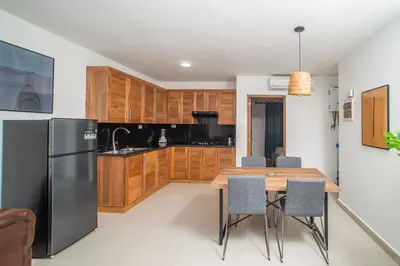 a kitchen with a wooden table and a black refrigerator at CMB202 BEACH AREA Res Cristamar in Eslabón