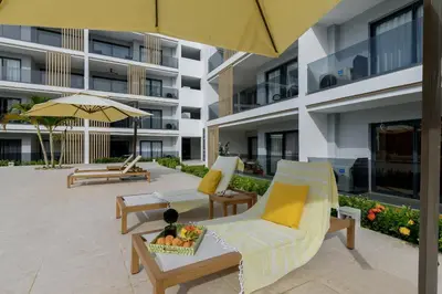 a hotel patio with chairs and an umbrella at Sausalito | Relax Vista Piscina in Punta Cana