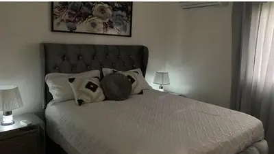 a bedroom with a bed with white sheets and pillows at Residencial Mediterraneo in Santiago de los Caballeros