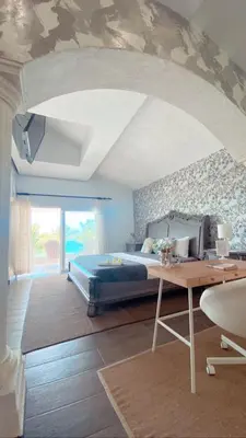 a bedroom with a bed and a desk in a room at Villa Ruben Juan Dolio in Juan Dolio