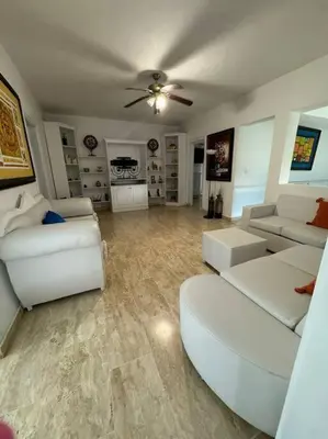a living room with white furniture and a ceiling fan at VILLA EN CASA DE CAMPO, La Romana, Rep Dom in La Romana