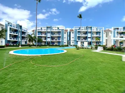 a large apartment complex with a large pool in the grass at Apartamento tipo hotel WIFI - Estacionamiento in Punta Cana