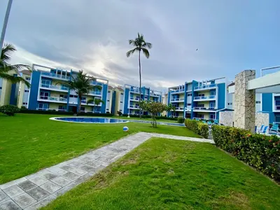 a park in front of a large apartment building at Apartamento tipo hotel WIFI - Estacionamiento in Punta Cana