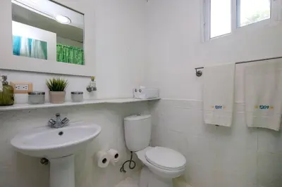 a white bathroom with a toilet and a sink at Las Terrenas Haven in Las Terrenas