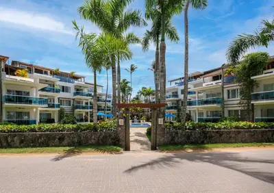 a building with palm trees in front of it at Las Terrenas Haven in Las Terrenas