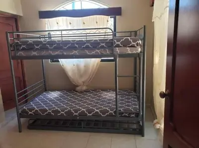 a metal bunk bed in a room with a window at Home away from Home in La Villa Isabela in La Isabela