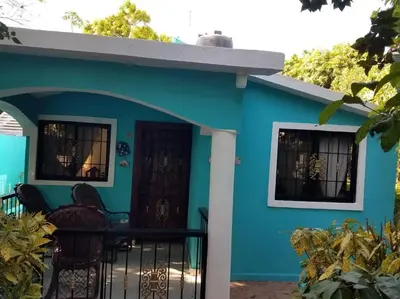 a blue house with a black fence in front of it at Home away from Home in La Villa Isabela in La Isabela