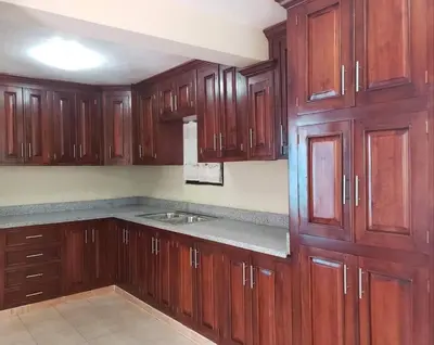 a kitchen with wooden cabinets and a sink at Home away from Home in La Villa Isabela in La Isabela