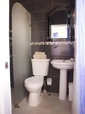 a bathroom with a toilet and a sink at Encantador Apartamento con agua caliente in Los Paredones