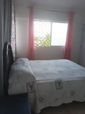 a bedroom with a bed and a window with red curtains at Encantador Apartamento con agua caliente in Los Paredones