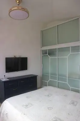a bedroom with a bed and a flat screen tv at Encantador Apartamento con agua caliente in Los Paredones