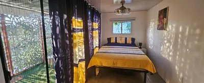 a bedroom with a bed and a large window at BlueEcolandia Bungalow TIERRA in Jarabacoa