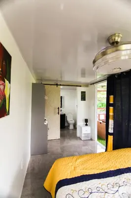 a bedroom with a bed and a bathroom at BlueEcolandia Bungalow TIERRA in Jarabacoa