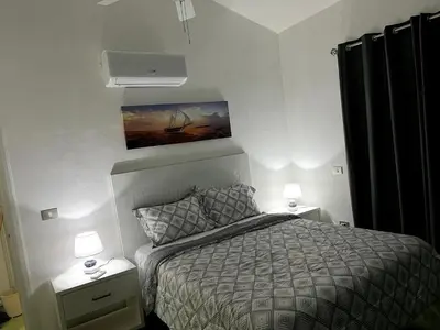 a bedroom with a bed and two night stands with lamps at Apto CGM Esmeralda in Bayahibe