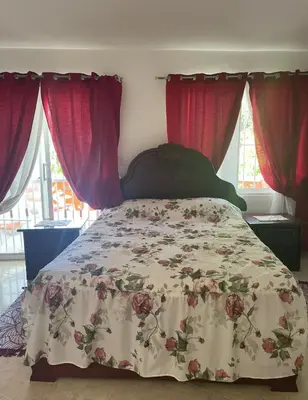 a bedroom with a bed with a floral bedspread at Villa Fiordalisa in San Felipe de Puerto Plata