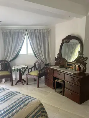 a bedroom with a dresser and a mirror and a bed at Villa Fiordalisa in San Felipe de Puerto Plata