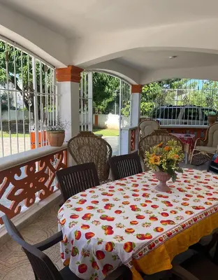a table on a porch with flowers on it at Villa Fiordalisa in San Felipe de Puerto Plata