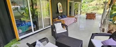 a patio with chairs and tables on a building at Rincón de Paz in Jarabacoa