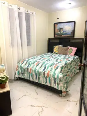 a bedroom with a bed with a colorful comforter at Fantástico con luz aire tv y cocina in La Romana