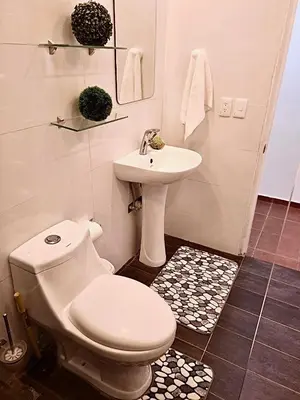 a bathroom with a white toilet and a sink at Escapade Apartments in Cabarete