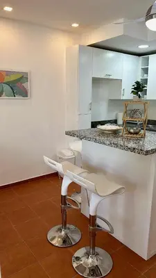 a kitchen with two bar stools and a counter at Escapade Apartments in Cabarete