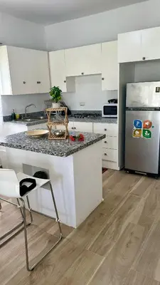 a white kitchen with a counter and a refrigerator at Escapade Apartments in Cabarete