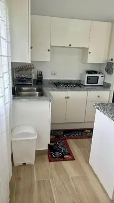a kitchen with white cabinets and a sink at Escapade Apartments in Cabarete