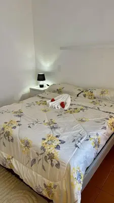 a bed with a flowery comforter on it at Escapade Apartments in Cabarete