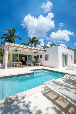a villa with a swimming pool and a house at Chameleon Village in El Limón