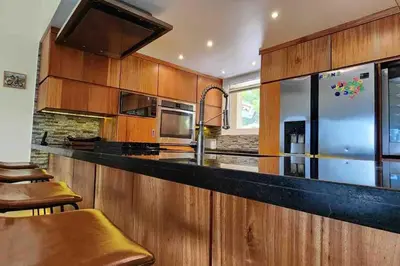 a kitchen with wooden cabinets and a black counter top at Velero Beach Cabarete 2 bedroom Penthouse in Cabarete