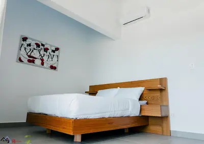 a bedroom with a wooden bed with white sheets at Caribey2 APT 2A3 in Las Terrenas