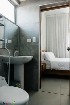 a bathroom with a sink and a bedroom with a bed at Caribey2 APT 2A3 in Las Terrenas
