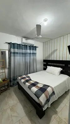 a bedroom with a bed with a blanket on it at Céntrico con wifi, luz,gas, TV y aire incluido in La Romana