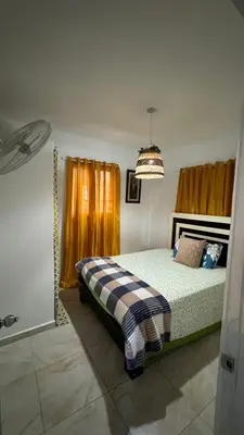 a bedroom with a bed and a chandelier at Céntrico con wifi, luz,gas, TV y aire incluido in La Romana