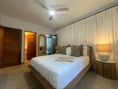 a bedroom with a large white bed and a lamp at Luxury 2 Bedroom Apartment, 1 Min Walk to Punta Popy Beach, Pool, AC, Fast WiFi, Las Terrenas in Las Terrenas